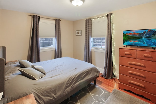 bedroom featuring multiple windows and light wood-style flooring