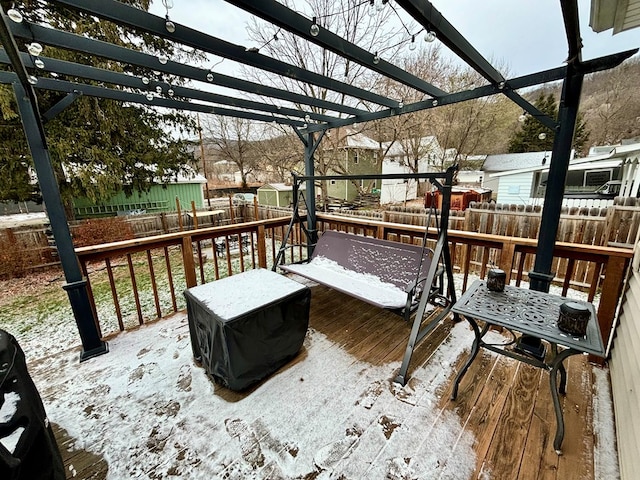 snow covered deck featuring a fenced backyard and a pergola