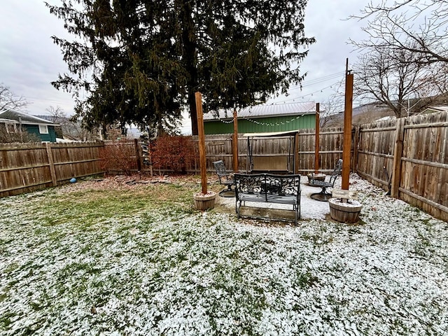 yard layered in snow featuring a patio area and a fenced backyard