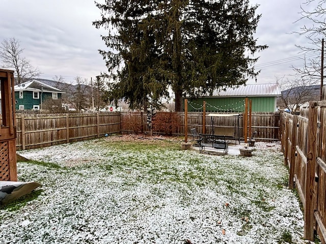 yard covered in snow featuring a patio and a fenced backyard