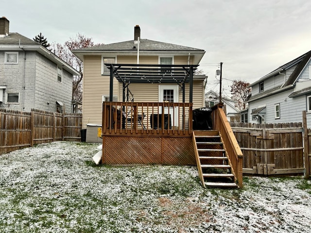 snow covered house featuring a fenced backyard, stairs, a deck, and a pergola