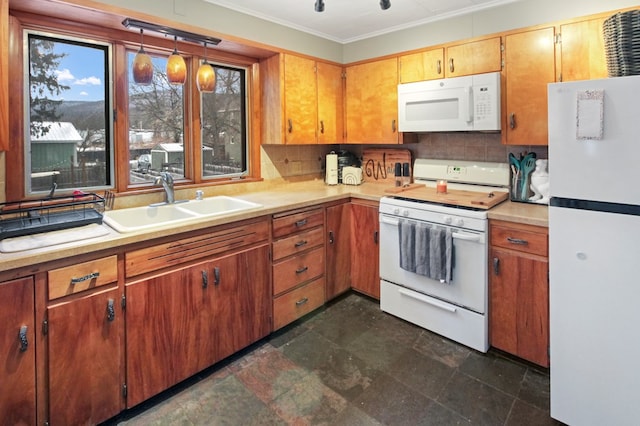 kitchen featuring crown molding, light countertops, decorative backsplash, a sink, and white appliances