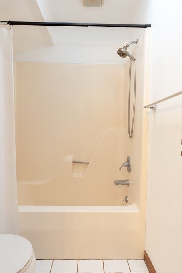 bathroom with tile patterned floors, shower / tub combo with curtain, and toilet