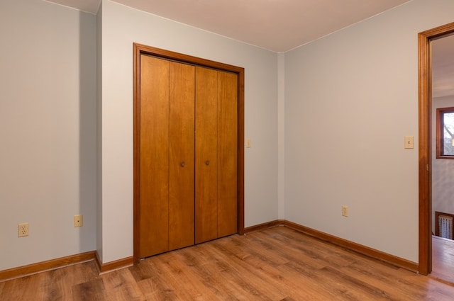 unfurnished bedroom featuring light wood-type flooring and a closet