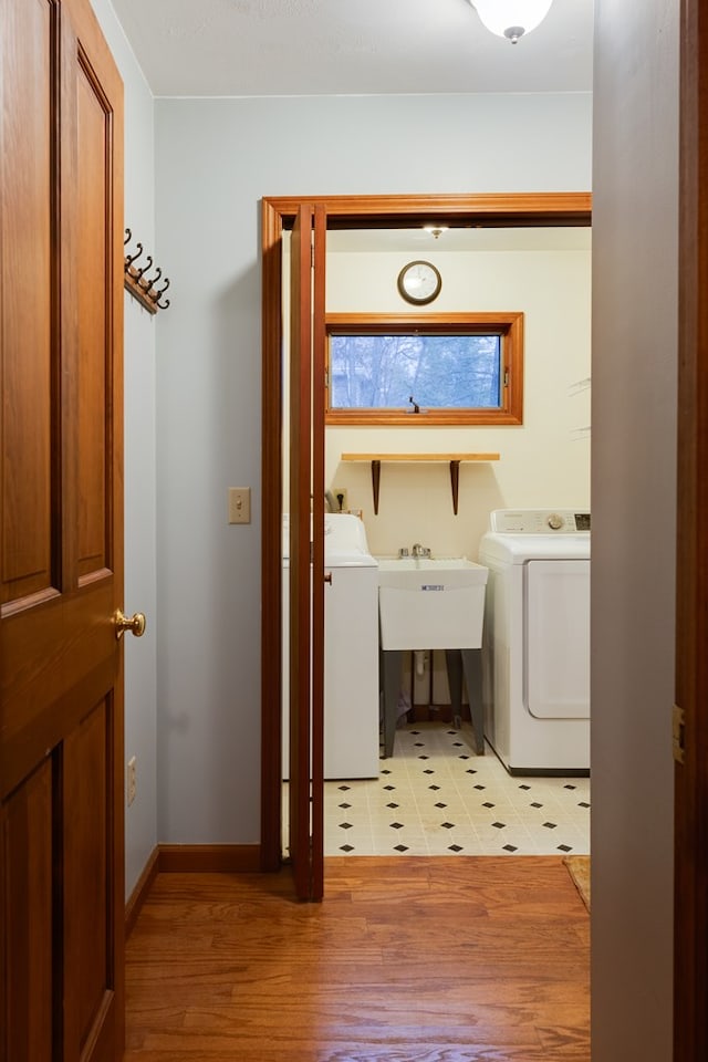 washroom featuring washer and dryer, light hardwood / wood-style floors, and sink