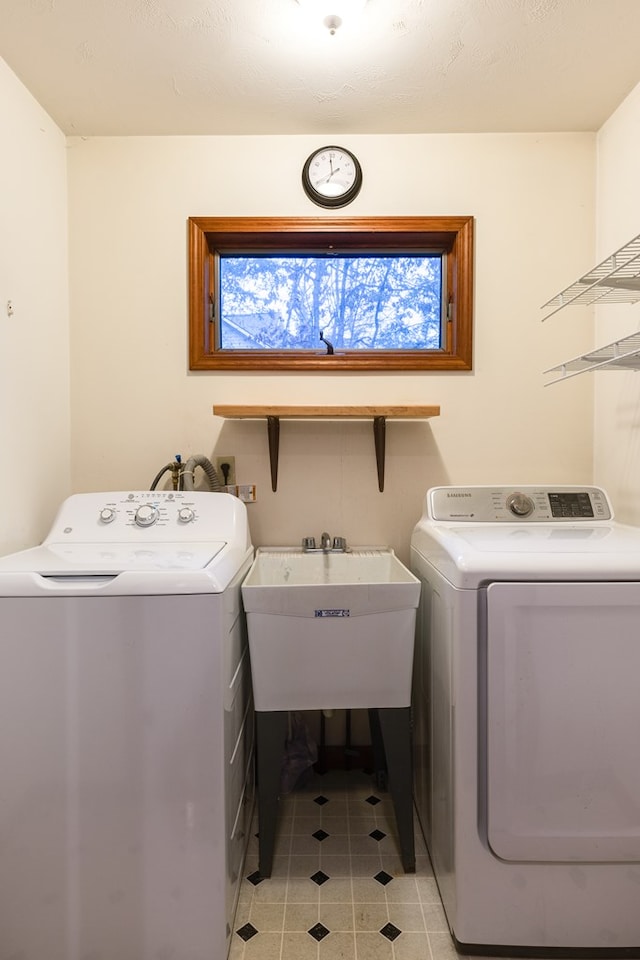 laundry area with separate washer and dryer and sink