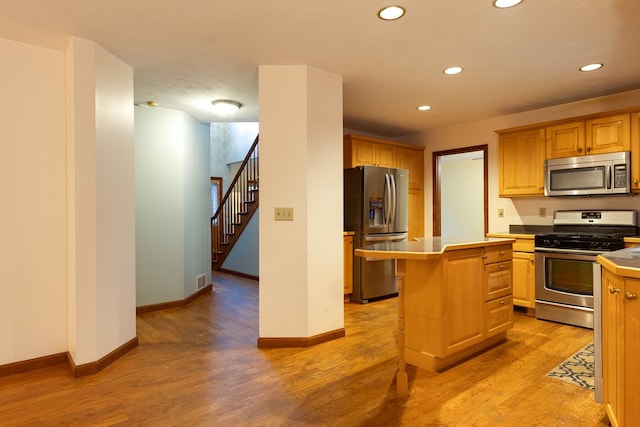 kitchen featuring stainless steel appliances, a kitchen island, and light hardwood / wood-style floors