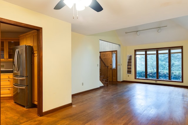 spare room featuring dark hardwood / wood-style flooring, track lighting, vaulted ceiling, and ceiling fan