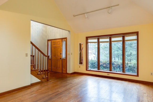 entryway featuring hardwood / wood-style floors, high vaulted ceiling, and track lighting