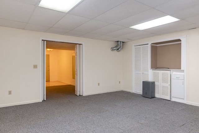 carpeted spare room featuring a drop ceiling