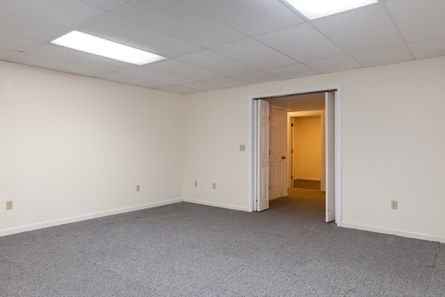 empty room with carpet flooring and a paneled ceiling