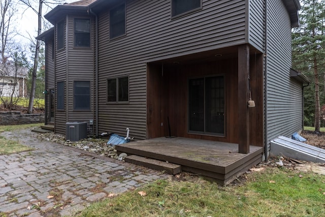 rear view of property featuring central AC and a wooden deck