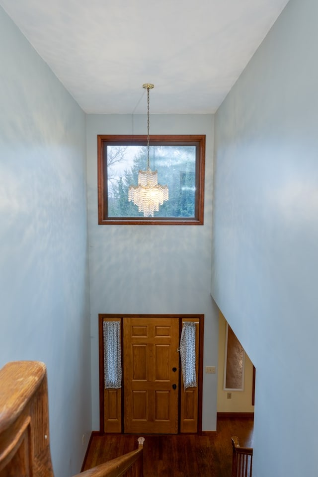 entrance foyer with dark wood-type flooring and a notable chandelier