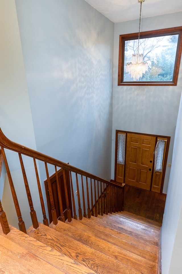 staircase featuring hardwood / wood-style flooring and a chandelier