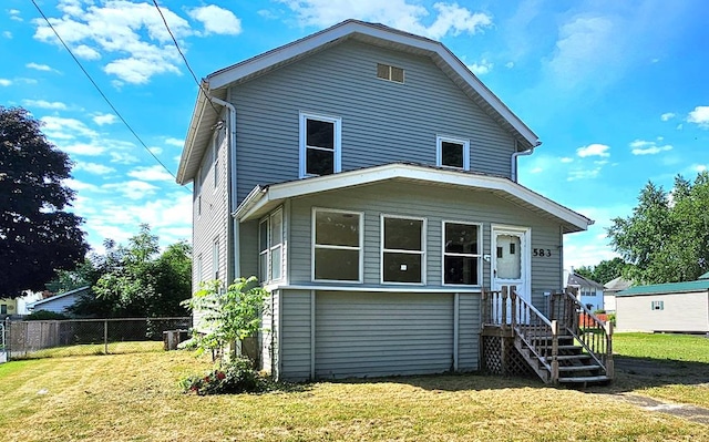 rear view of house featuring a lawn