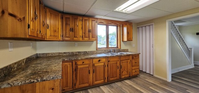 kitchen with hardwood / wood-style floors, a paneled ceiling, and sink