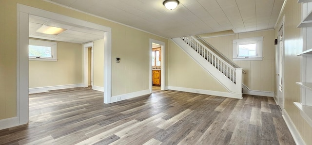 unfurnished living room featuring hardwood / wood-style flooring, a healthy amount of sunlight, and ornamental molding