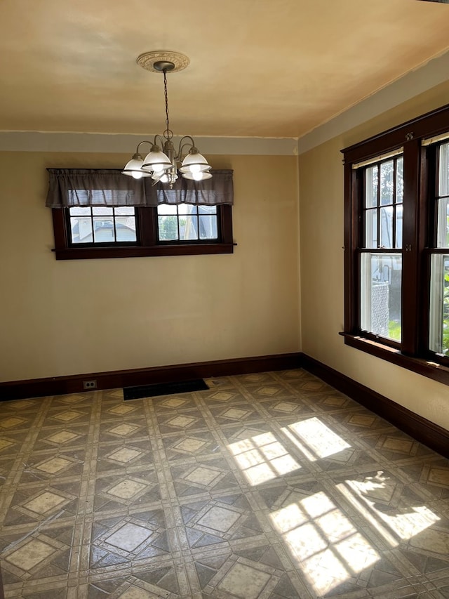 unfurnished room with an inviting chandelier