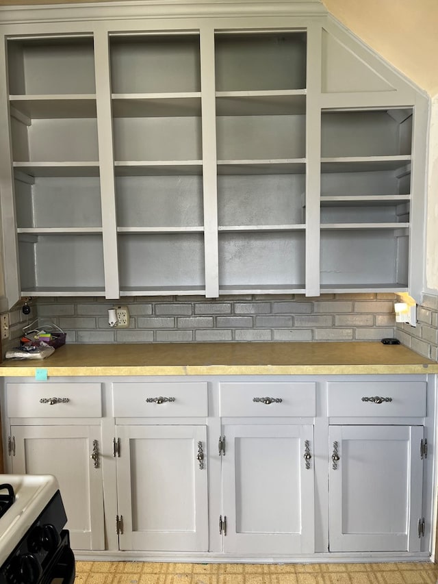 kitchen featuring white cabinets, decorative backsplash, and white range oven