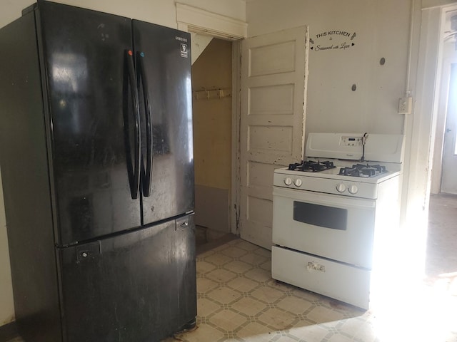 kitchen with black fridge and white gas range