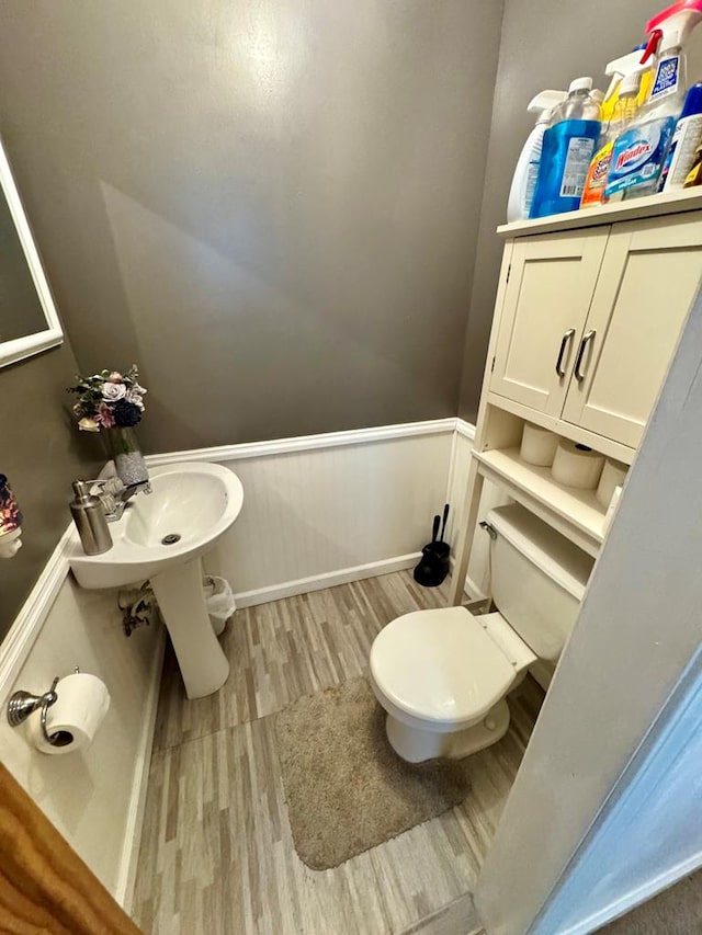 bathroom with toilet, sink, and hardwood / wood-style floors