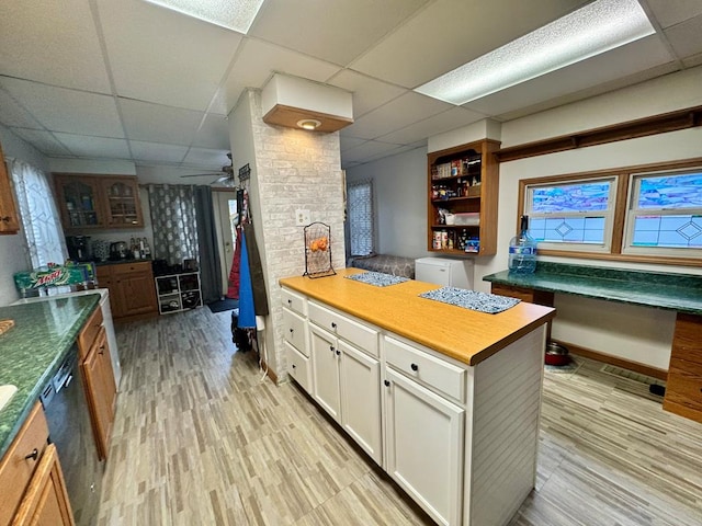 kitchen with a paneled ceiling, light hardwood / wood-style floors, white cabinetry, and dishwasher