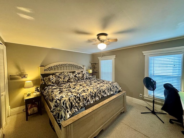 carpeted bedroom with ceiling fan and ornamental molding