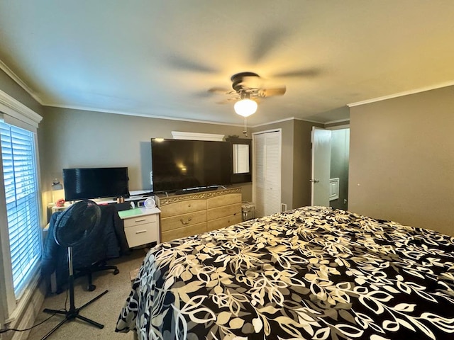 bedroom featuring ornamental molding, ceiling fan, a closet, and light carpet