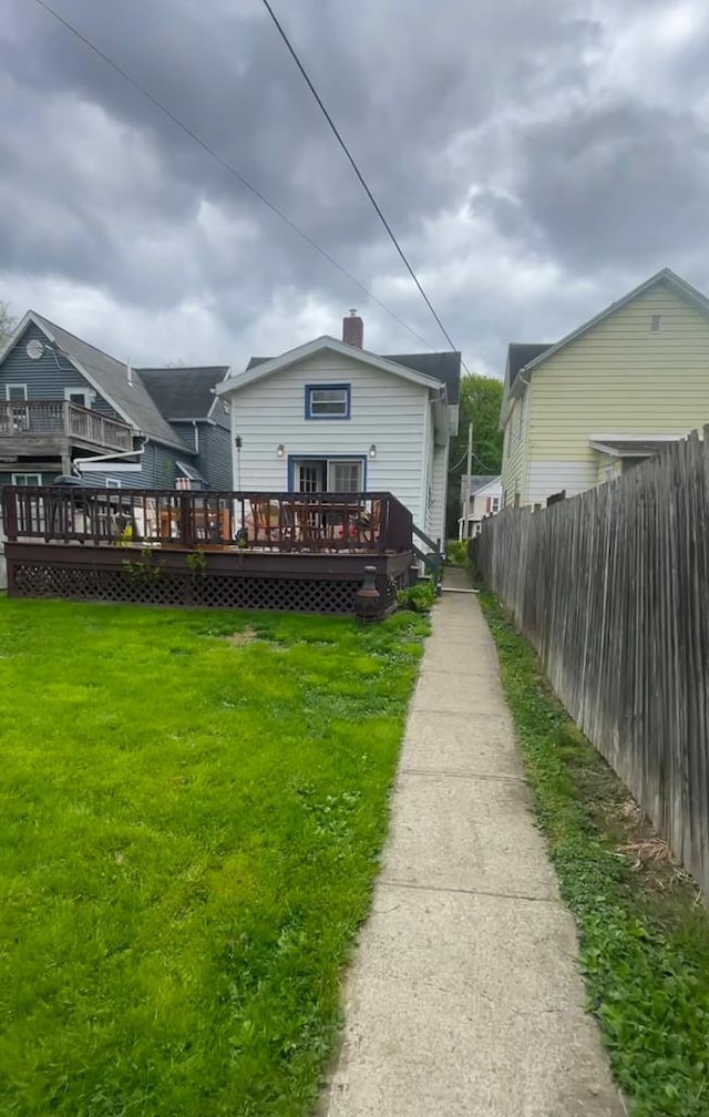 back of house featuring a yard and a wooden deck