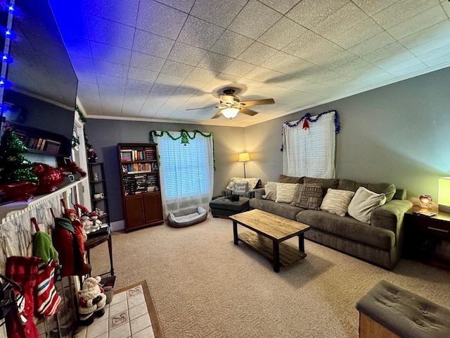 carpeted living room featuring ceiling fan and crown molding