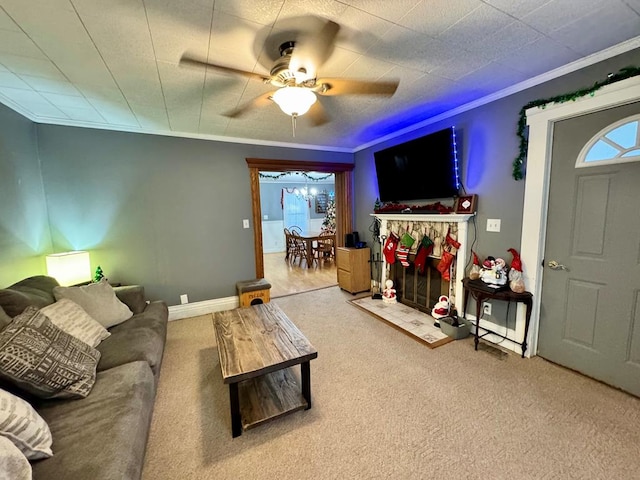 living room with ceiling fan, crown molding, carpet floors, and a fireplace