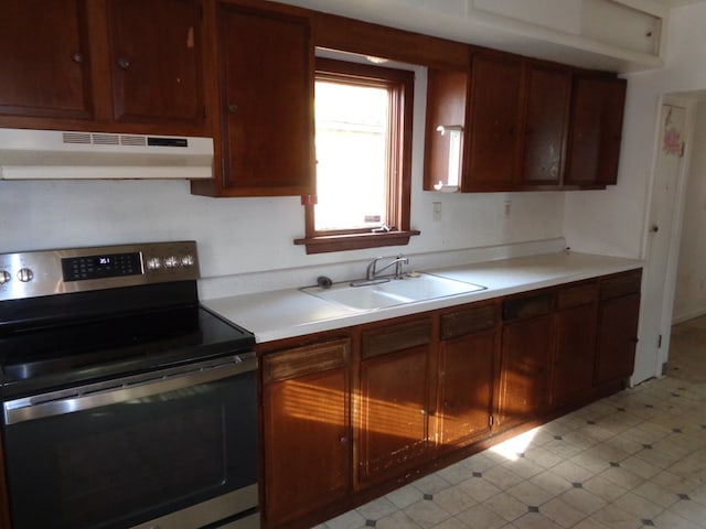 kitchen with electric stove, sink, and range hood