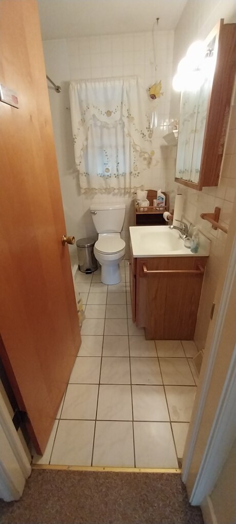 bathroom with tile patterned flooring, vanity, and toilet