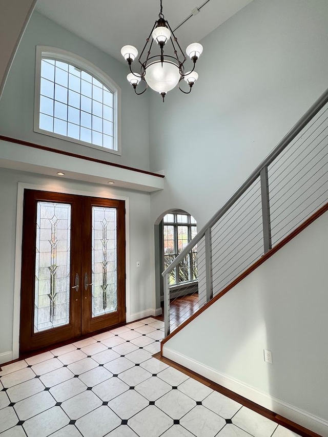 entryway featuring a notable chandelier, a high ceiling, and french doors