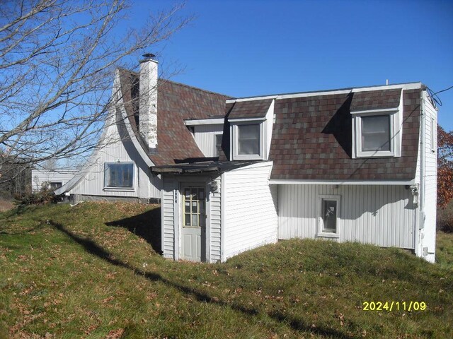 rear view of house featuring a yard