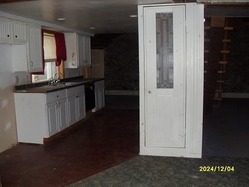 kitchen featuring white cabinetry, black dishwasher, and sink