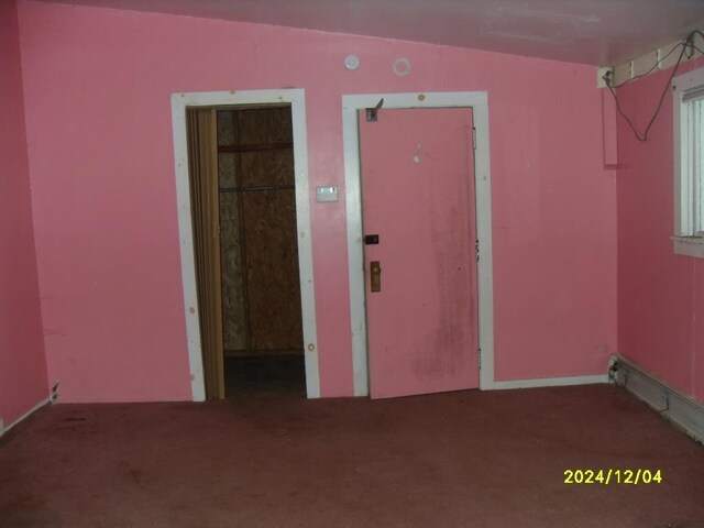 unfurnished room with vaulted ceiling and carpet floors