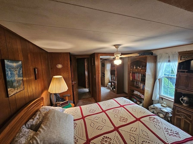 bedroom featuring carpet flooring, ceiling fan, and wood walls