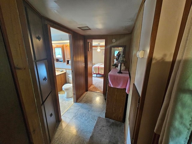 bathroom featuring vanity, ceiling fan, and wood walls