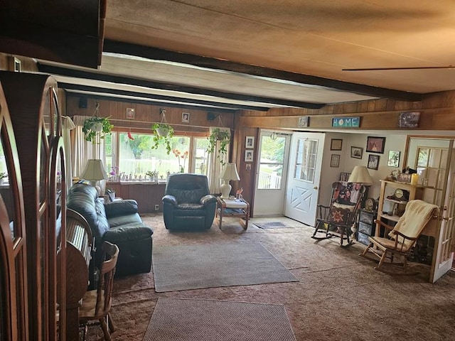 living room with beamed ceiling, carpet floors, and wooden walls