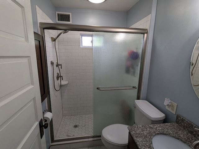 bathroom with vanity, toilet, and a shower with shower door