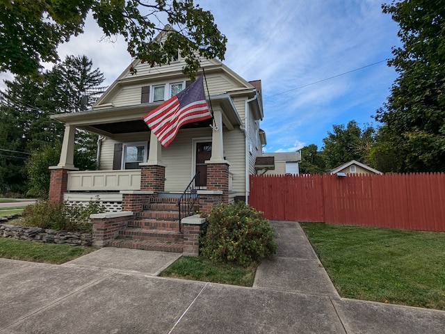 view of front of home with covered porch and a front yard