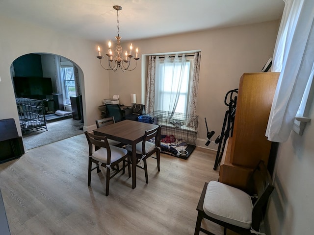 dining space featuring an inviting chandelier and light hardwood / wood-style flooring