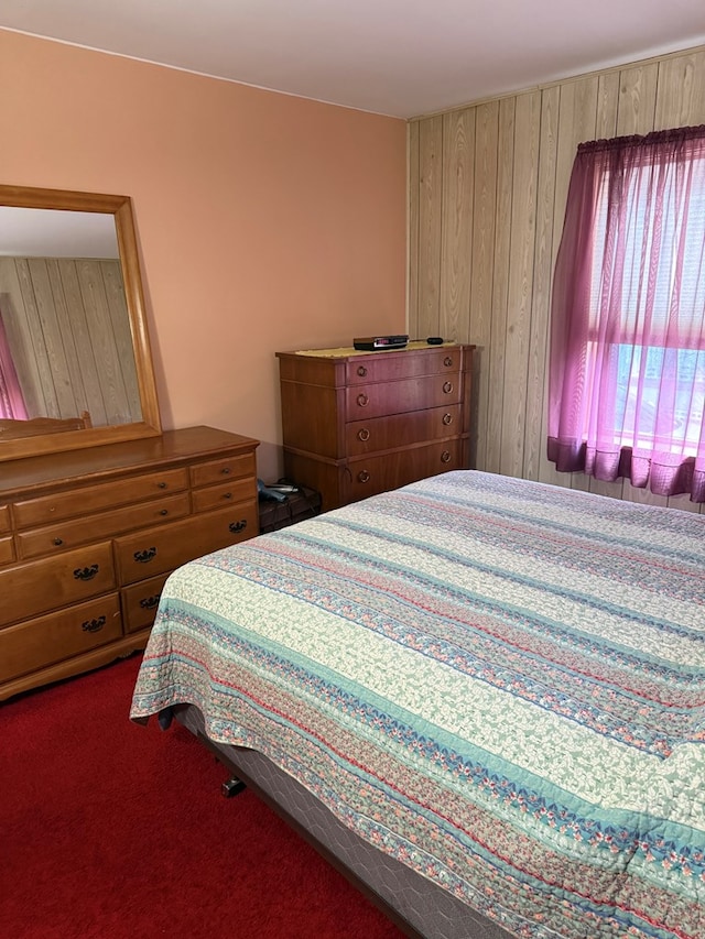 carpeted bedroom with wooden walls