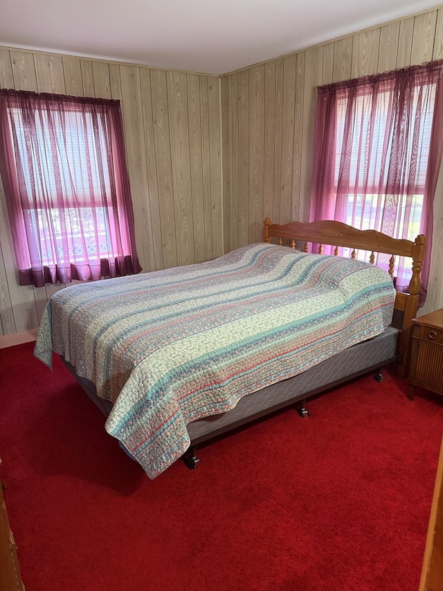 bedroom featuring carpet flooring and wooden walls