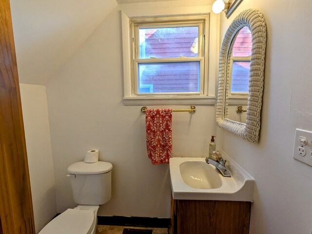 bathroom featuring vanity, toilet, and lofted ceiling