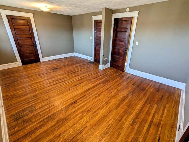 unfurnished bedroom featuring a closet, wood-type flooring, and a textured ceiling