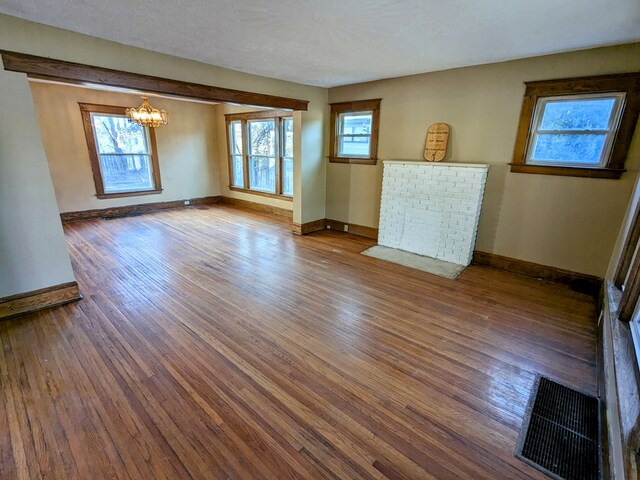 interior space with a chandelier, a healthy amount of sunlight, and hardwood / wood-style flooring