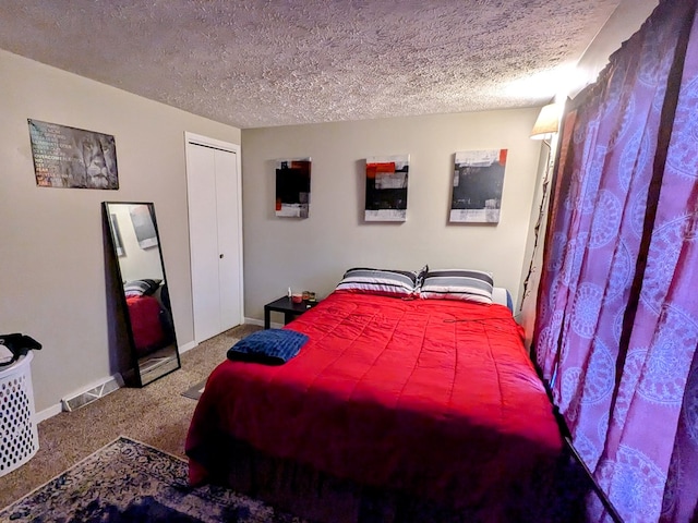 carpeted bedroom with a textured ceiling and a closet