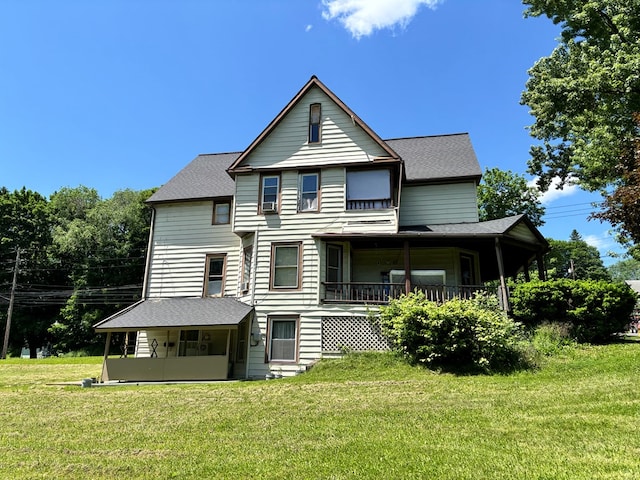 back of house with a sunroom and a lawn